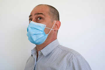 Man wearing a surgical face mask to stop the spread of the Coronavirus Covid 19