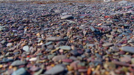 Pebbles and course sand on the beach in sunshine