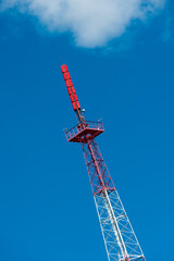 red and white cell tower in front of blue sky