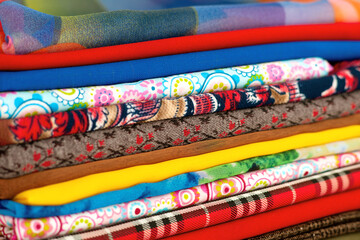 Cotton fabric background. A lot of cotton fabric close up. Multi-colored natural textiles for sewing clothes and bed linen. Different fabric texture.