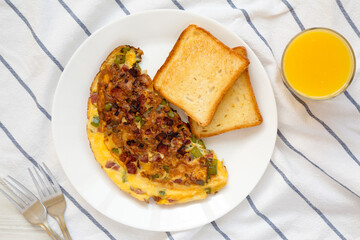 Homemade Denver Omelette on a white plate on cloth, top view. Flat lay, overhead, from above.