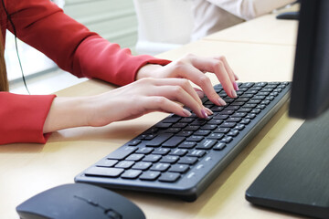 Close up on asian businesswomen hands typing Keyboard with a cup of coffee on computer desk in office