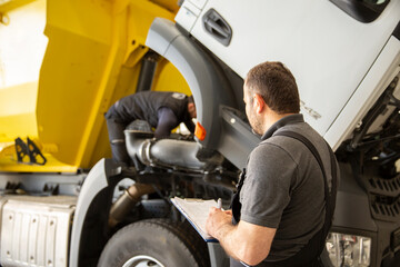 Professional technician checking truck maintenance list, truck service