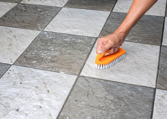 Men's hands are used to convert polishing cleaning on the tile floor.