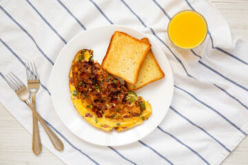 Homemade Denver Omelette on a white plate on cloth, overhead view. Flat lay, top view, from above.