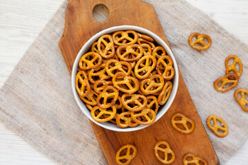 Crispy Pretzel Crackers in a Gray Bowl on a white wooden background, top view. Flat lay, overhead, from above.