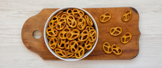 Crispy Pretzel Crackers in a Gray Bowl on a rustic wooden board, top view. Flat lay, overhead, from above.