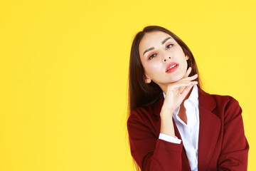 Beauty make up and good skin face of smart businesswoman in red suit isolate on yellow background