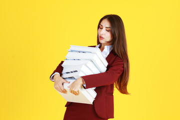 Businesswoman in red suit hand holding document books isolated on yellow background. Copy Space