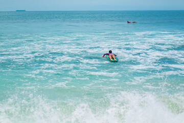 Sexy slim girl riding on surf board in the ocean. Healthy active lifestyle in summer vocation.