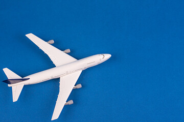 Concept of travel vacation. Top view white toy airplane isolated on green background with copy space. Minimal think.