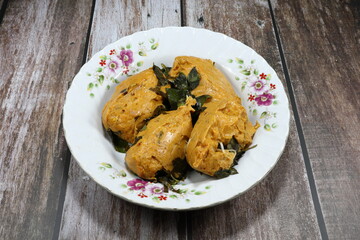 Traditional Steamed fish mixed with curry paste and coconut milk on the plate. Famous Thai local spicy seafood in Asia restaurant.