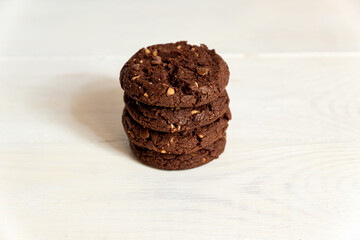 Stuck of Homemade american chocolate cookies with nuts on white wooden background. Fresh pastry.