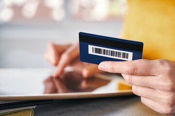 Close up shot of bank card in hand of woman. Shopping online from home