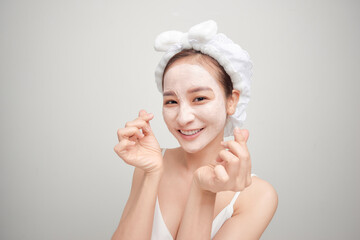 Woman on a white background clean face cream on face towel in hair on head