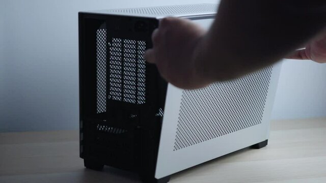 a man is assemble and dismental of compact mini itx pc case. Mini itx builder case