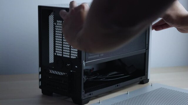 a man is assemble and dismental of compact mini itx pc case. Mini itx builder case