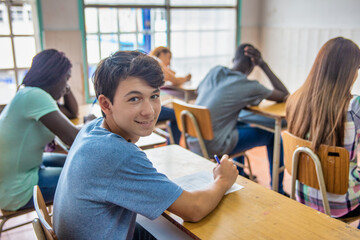 Multi ethnic teenager classroom at school making test