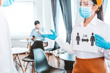 Obraz premium Asian waitress wear protective face mask explain and Using alcohol gel clean wash hand scan customer temperature