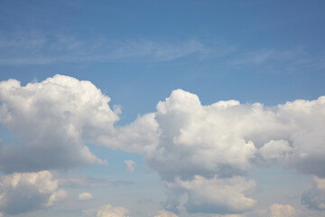 Naklejka na ściany i meble Weißen Wolken am blauem Himmel zur Mittagszeit im Sommer.