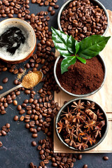 Coffee beans, milled coffee and spices on dark background