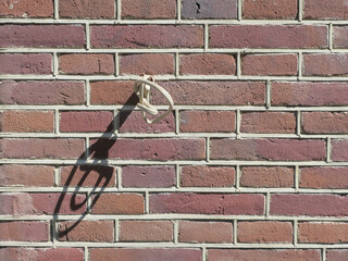 electricity cable coming out off a red brick wall