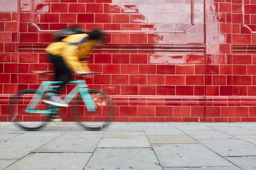Motion blurred bike. Young afro man bike rider and a fixed bike in a street of London