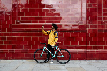 Young afro man takes a selfie with his fixed gear bike in a suburb of London