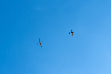 glider in tow with a plane in the sky