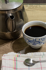 Close up shot of a kettle and a cop of coffee