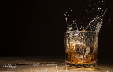 Close-up ice cubes falling into a glass