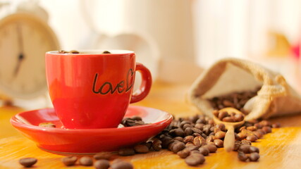 Red coffee cup with coffee beans on the table