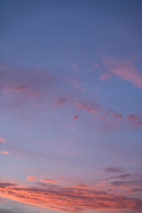 Beautiful evening blue sky at sunset with flaming bright light clouds. A warm summer evening at sunset.
