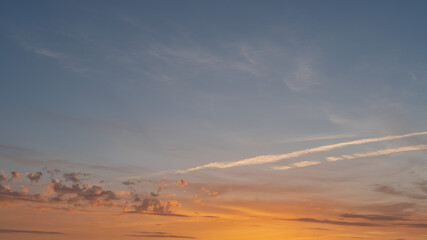 Beautiful evening blue sky at sunset with flaming bright light clouds. A warm summer evening at sunset.