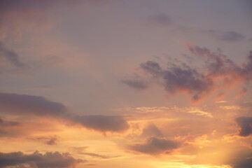 Beautiful evening blue sky at sunset with flaming bright light clouds. A warm summer evening at sunset.