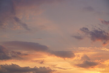 Beautiful evening blue sky at sunset with flaming bright light clouds. A warm summer evening at sunset.