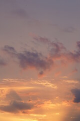Beautiful evening blue sky at sunset with flaming bright light clouds. A warm summer evening at sunset.