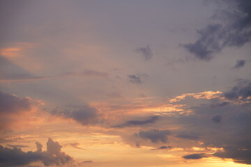 Beautiful evening blue sky at sunset with flaming bright light clouds. A warm summer evening at sunset.