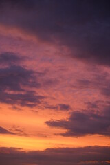 Beautiful evening blue sky at sunset with flaming bright light clouds. A warm summer evening at sunset.