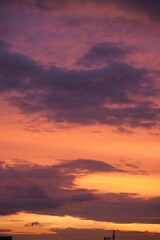 Beautiful evening blue sky at sunset with flaming bright light clouds. A warm summer evening at sunset.