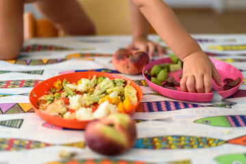 Detail of a plate with vegetables for children on a table.