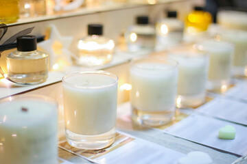 Scented candles for home with various compositions. Perfumed smells in bottles. Stand at exhibition of DIY handmade products. Market of small business. Fashionable accessories for home decoration