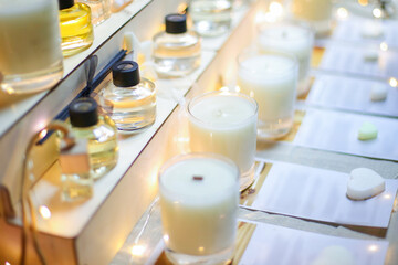 Scented candles for home with various compositions. Perfumed smells in bottles. Stand at exhibition of DIY handmade products. Market of small business. Fashionable accessories for home decoration