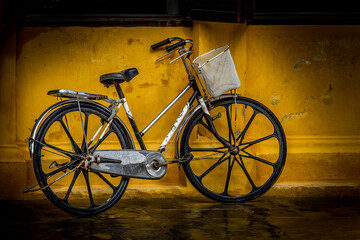 Fototapeta na wymiar Ladies bicycle against yellow wall Hoi An
