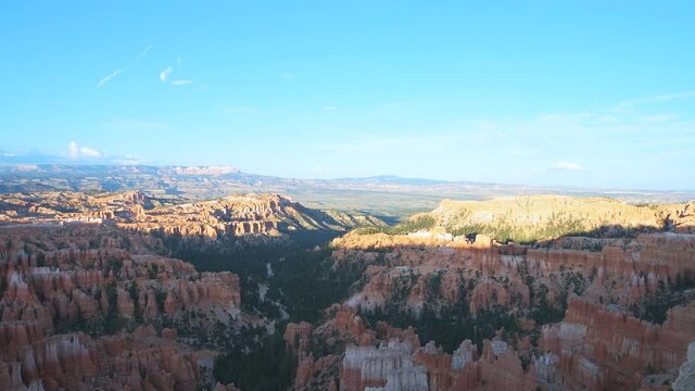 Aerial above view from overlook panoramic horizontal panning of dark evening sunset hoodoos rock formations in Bryce Canyon National Park in Utah with sunlight amphitheater