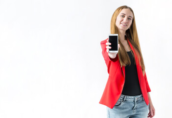 Portrait of a smiling girl who is standing with her hand outstretched forward holding a phone on a white background