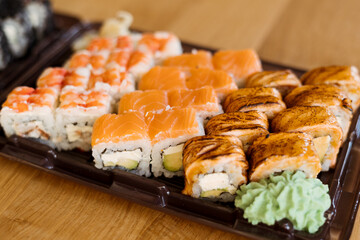 Sushi Roll Delivery. Salmon, eel, tuna, avocado, royal prawn, cream cheese Philadelphia, caviar tobica, chuka, sea cabbage shrimps on wood background