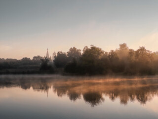 Fototapeta na wymiar Beautiful morning landscape with fog over the lake