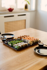 Close up of mix of sushi rolls on a table at home. Waiting friends to eat sushi rolls together using bamboo sticks.