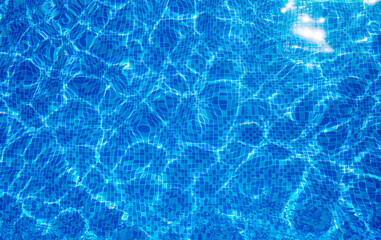 Background texture surface of blue swimming pool of water with refractive sun